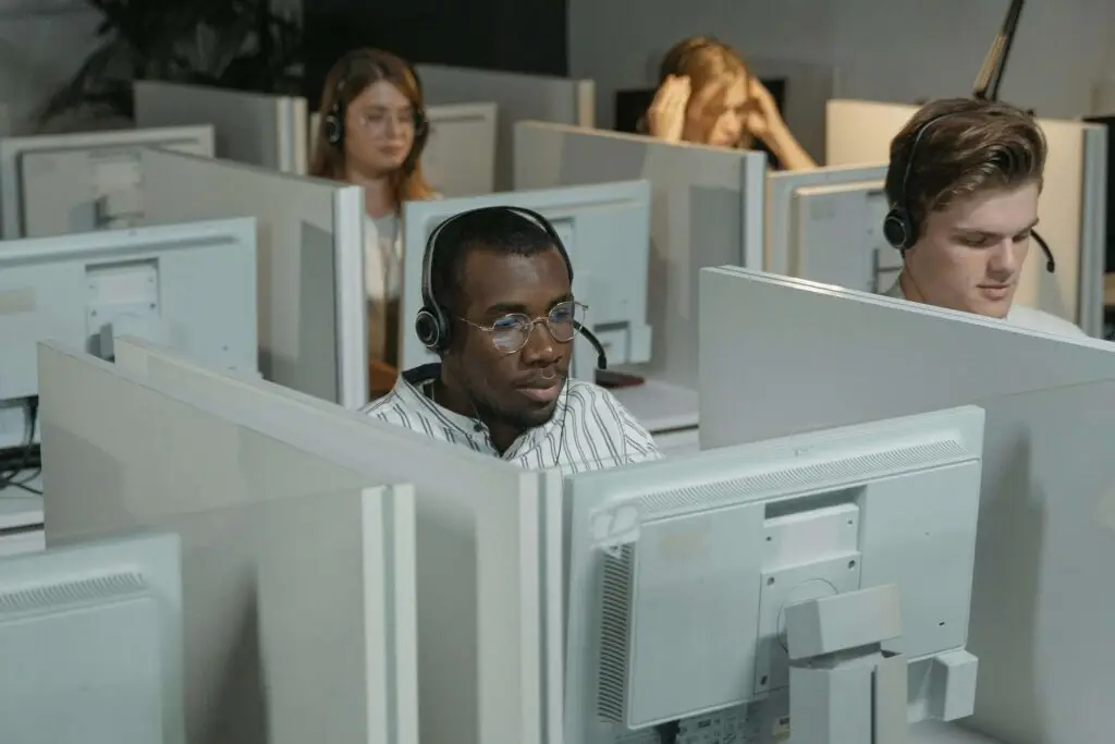 Call center agents working at computer stations with headsets on